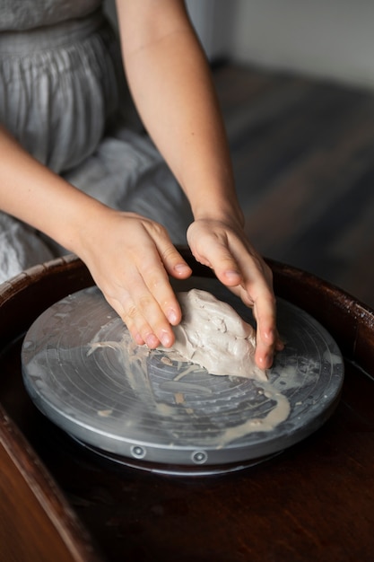 Photo gratuite sculpteur féminin travaillant avec de l'argile dans le studio