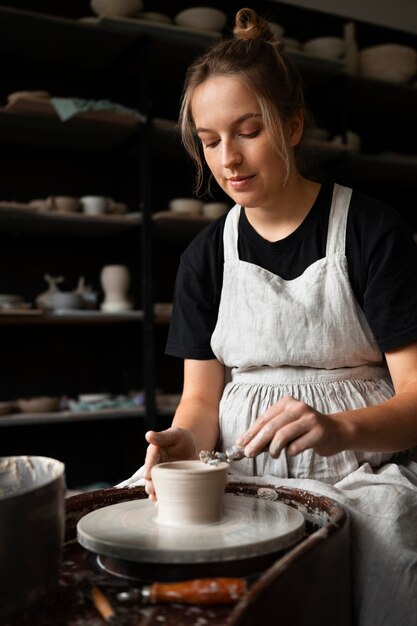 Sculpteur féminin travaillant avec de l'argile dans le studio