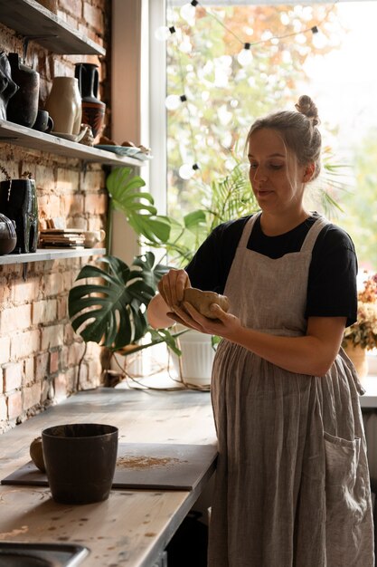 Sculpteur féminin travaillant avec de l'argile dans le studio