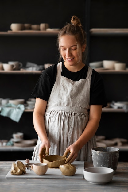 Sculpteur féminin travaillant avec de l'argile dans le studio