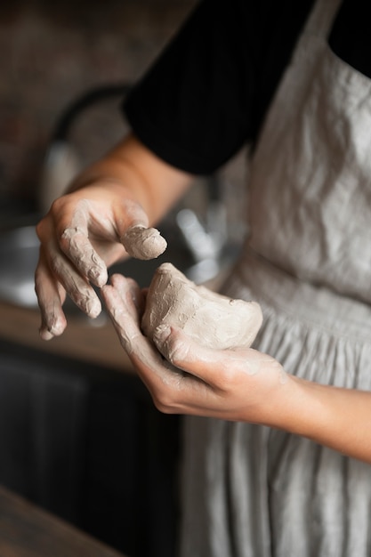 Sculpteur féminin travaillant avec de l'argile dans le studio