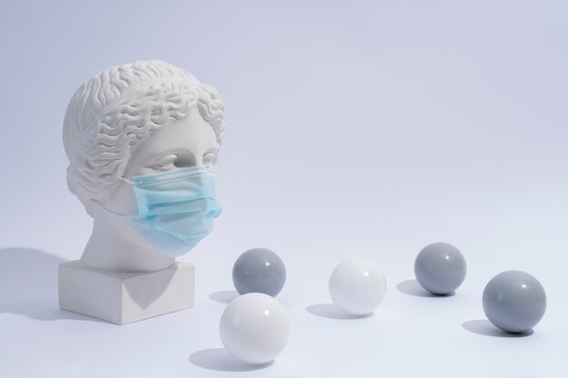 Sculpture en marbre de personnage historique avec masque médical et boules
