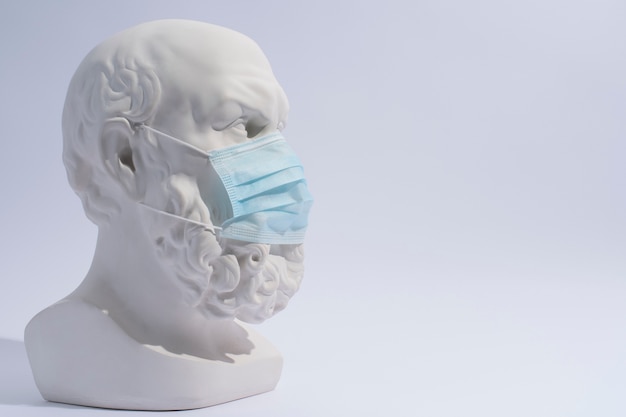 Sculpture en marbre de personnage historique avec masque médical