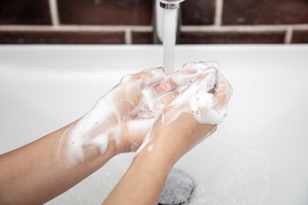 Se laver les mains à l'eau savonneuse sous l'eau courante. hygiène personnelle et santé.