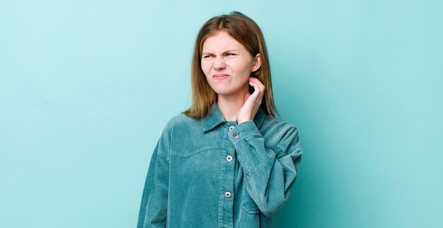 Se sentir stressé, frustré et fatigué en frottant le cou douloureux avec un regard inquiet et troublé