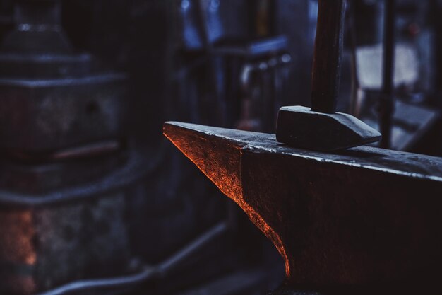 Séance photo en gros plan d'un marteau et d'une enclume à l'atelier dark smith.