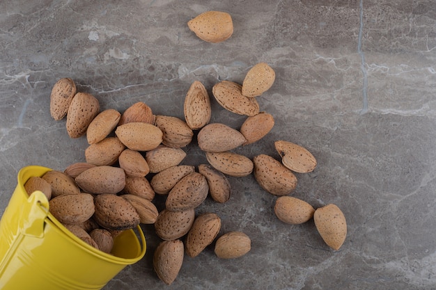 Seau et amandes sur la surface en marbre