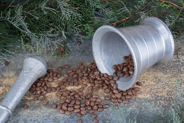 Un seau en fer avec des grains de café sur fond de marbre. photo de haute qualité