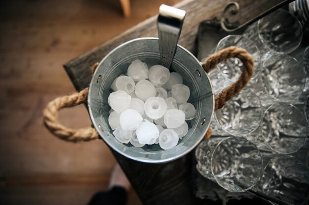 Seau à glace se dresse sur la table près des verres