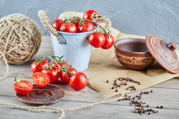 Seau De Tomates Et Tomates Coupées à Moitié Sur Table En Bois