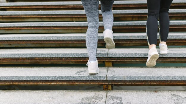 Section basse de deux coureurs féminins jogging dans les escaliers