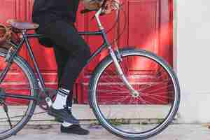 Photo gratuite section basse d'un homme assis sur un vélo