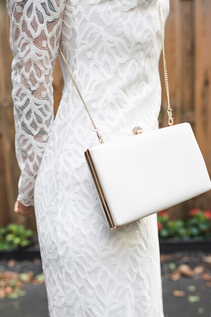 Section médiane d&#39;une femme en robe blanche avec pochette