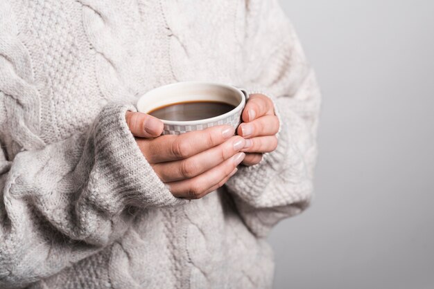 Section médiane d&#39;une femme en vêtements de laine tenant une tasse de café