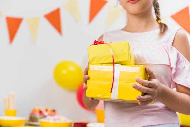 Section médiane d&#39;une fille tenant des boîtes-cadeaux à la main