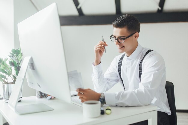 Une section médiane d'un homme d'affaires avec un ordinateur portable assis à la table, travaillant