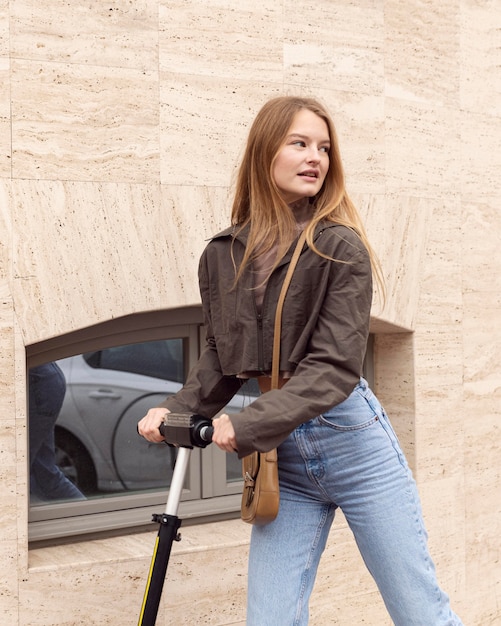 Séduisante femme équitation scooter électrique à l'extérieur