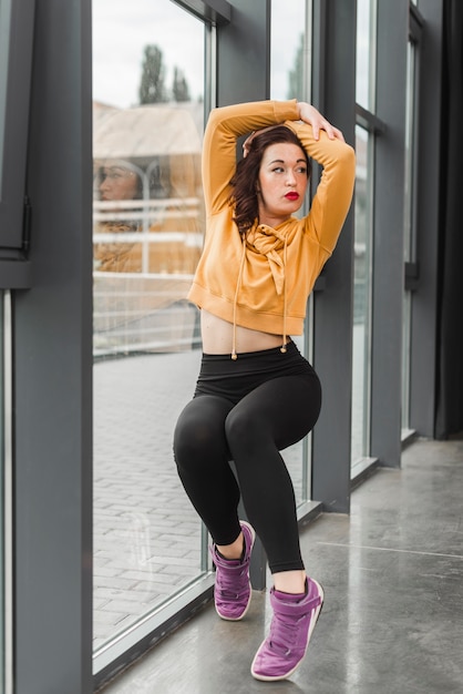 Séduisante jeune danseuse posant devant la fenêtre