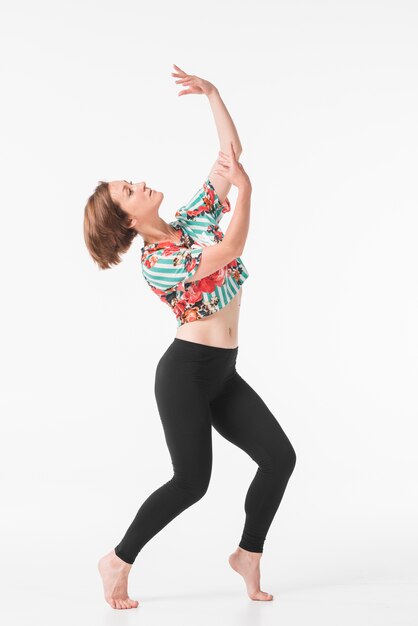 Séduisante jeune danseuse posant devant fond blanc