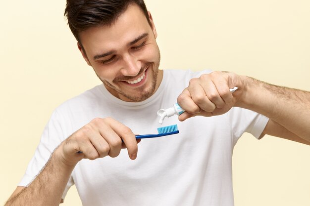 Séduisante jeune homme barbu se brosse les dents