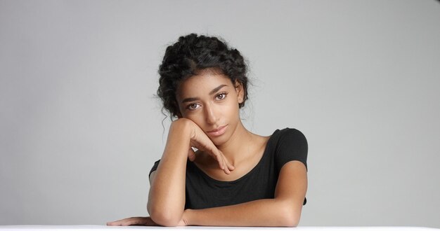 Séduisante jeune mannequin du Moyen-Orient touchant son joli visage avec une peau impeccable et souriante