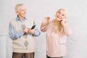 Photo gratuite senior couple écoutant de la musique sur smartphone