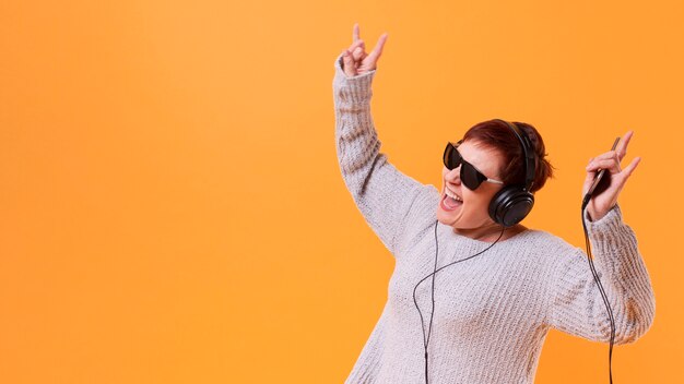 Senior femme danser et écouter de la musique avec espace de copie