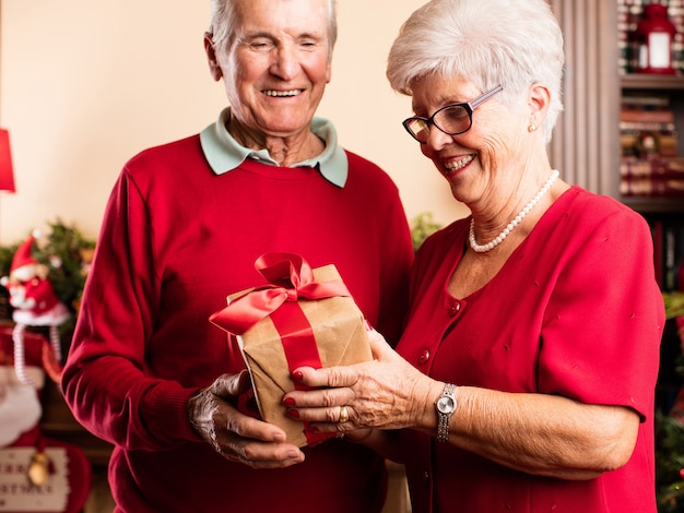 Senior femme donnant un cadeau à son mari