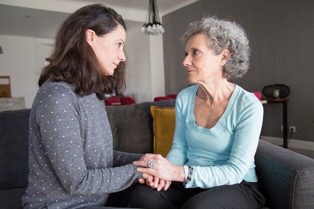 Senior femme et sa fille discutant en se regardant