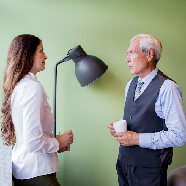 Senior homme d&#39;affaires et femme d&#39;affaires mature interagissant pendant une pause