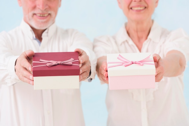 Senior homme gai et femme qui donne une boîte cadeau