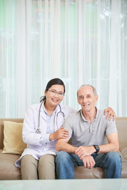 Senior homme et médecin assis sur un canapé dans le salon