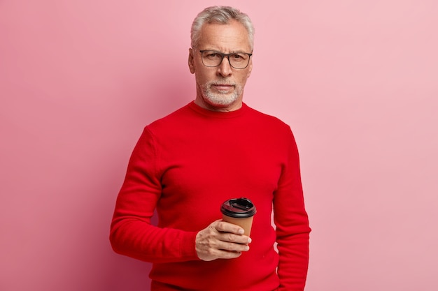 Senior homme portant un pull rouge et des lunettes à la mode