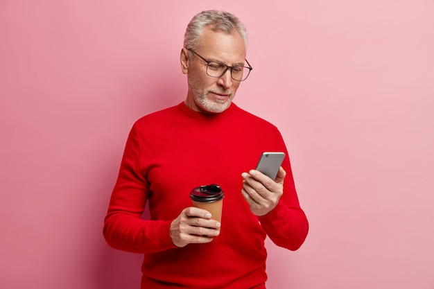 Senior homme portant un pull rouge et des lunettes à la mode