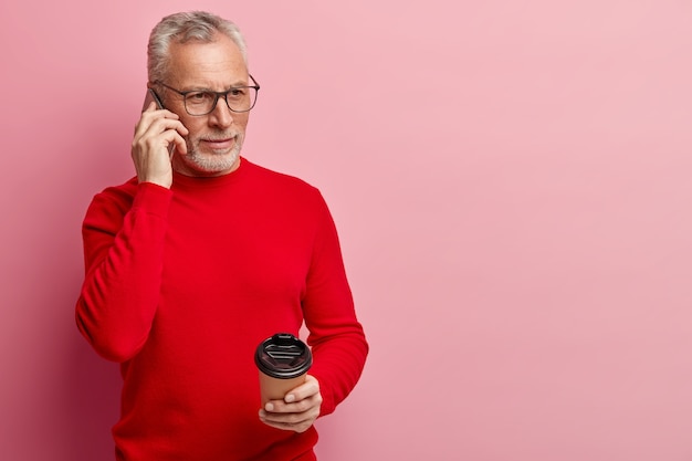 Senior homme portant un pull rouge et des lunettes à la mode