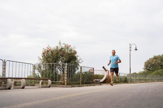 Senior homme pratiquant le jogging à l'extérieur par park