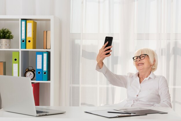 Senior avec des lunettes tenant le téléphone