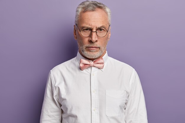 Senior man wearing white shirt et rose noeud papillon