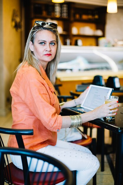 Sérieuse femme élégante posant au café