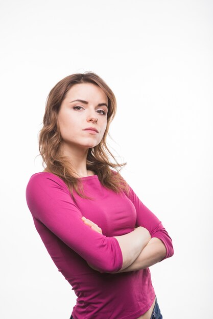 Sérieuse jeune femme avec ses bras croisés en regardant la caméra