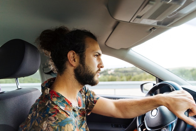 Photo gratuite sérieux homme barbu dans la voiture