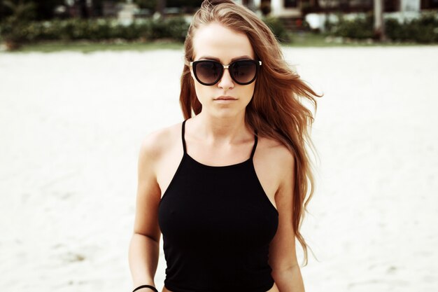 Serious femme aux cheveux longs sur la plage