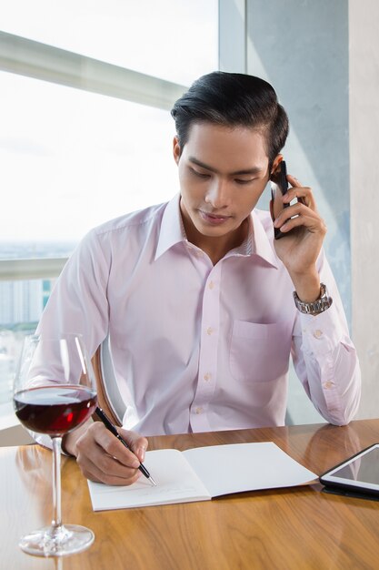 Serious jeune Asian Man Calling sur le téléphone dans le café