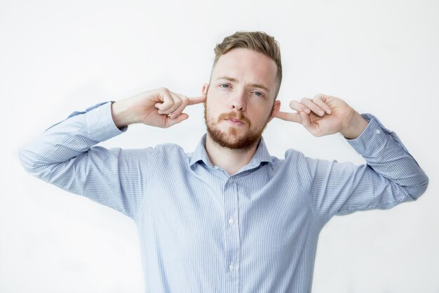 Serious Man Stopping Ears With Fingers