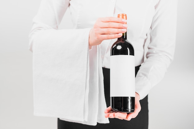 Serveur tenant et offrant une bouteille de vin