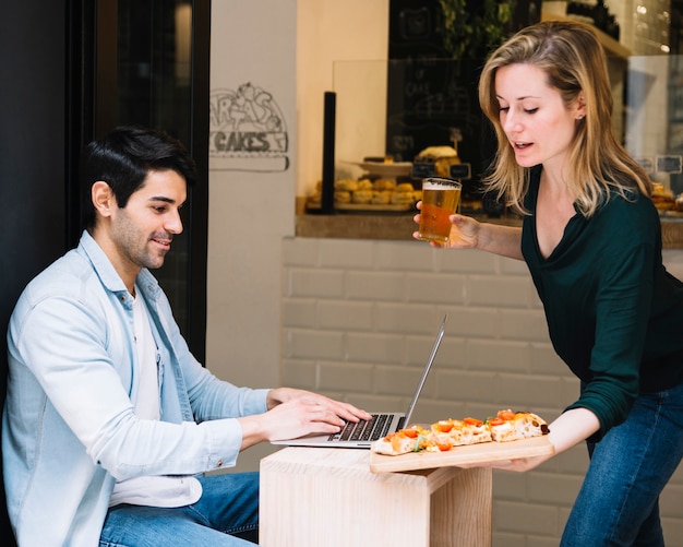 Serveuse apportant une commande à l&#39;homme au café