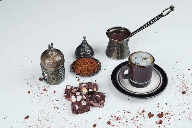 Service à café turc avec des tranches de gâteau au cacao.