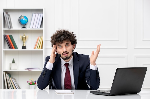 Service client beau jeune homme en costume de bureau avec ordinateur portable et casque en colère et irrité