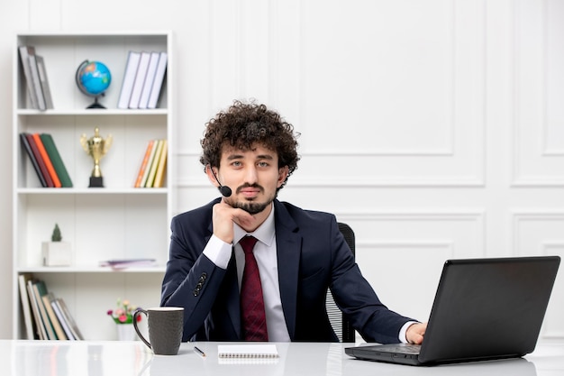 Service à la clientèle beau jeune homme en costume de bureau avec ordinateur portable et casque pensant et fatigué