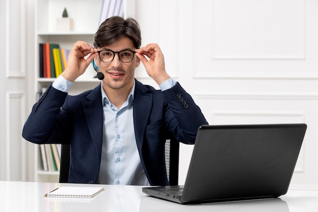 Service à la clientèle beau mec avec casque et ordinateur portable en costume mettant des lunettes